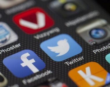 A detailed close-up of social media icons on a smartphone screen, including Facebook and Twitter.